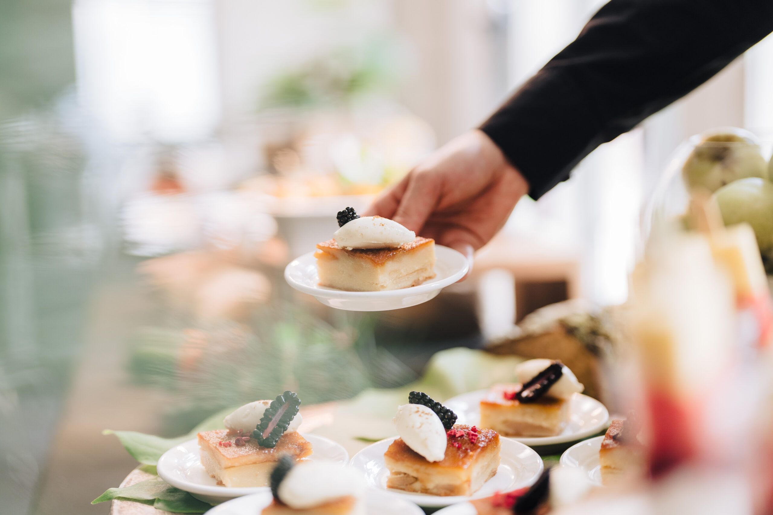 A person holding a plate with cake and ice cream