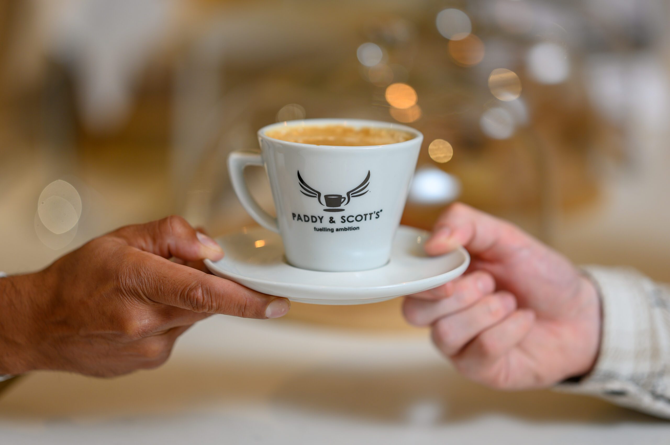 A hands holding up a cup of coffee