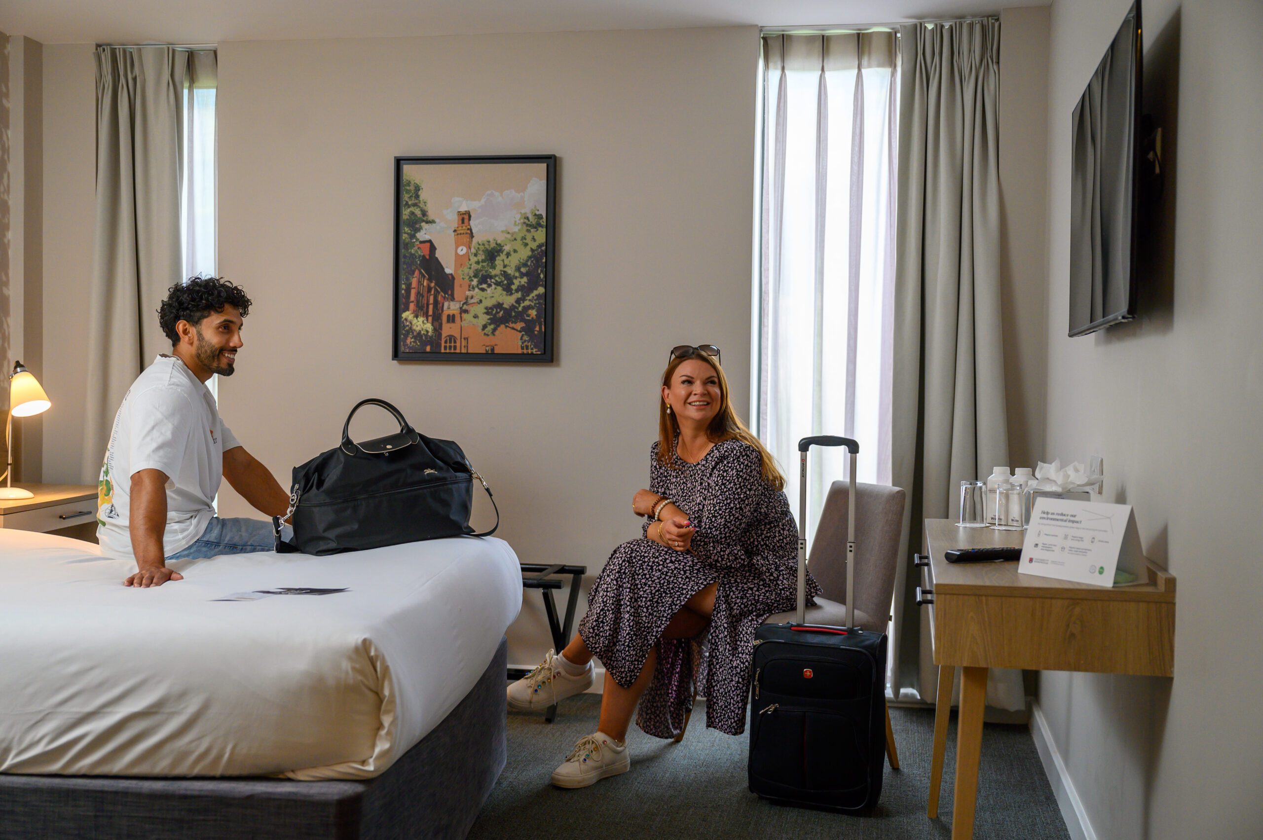 Two people sat watching the TV in their room