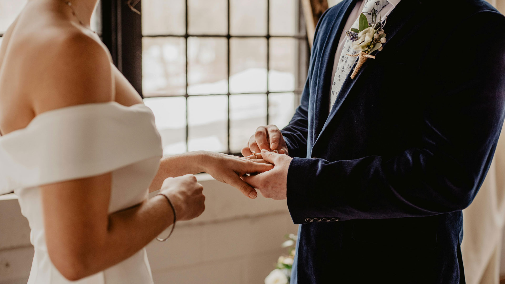 A groom putting a ring on the bride