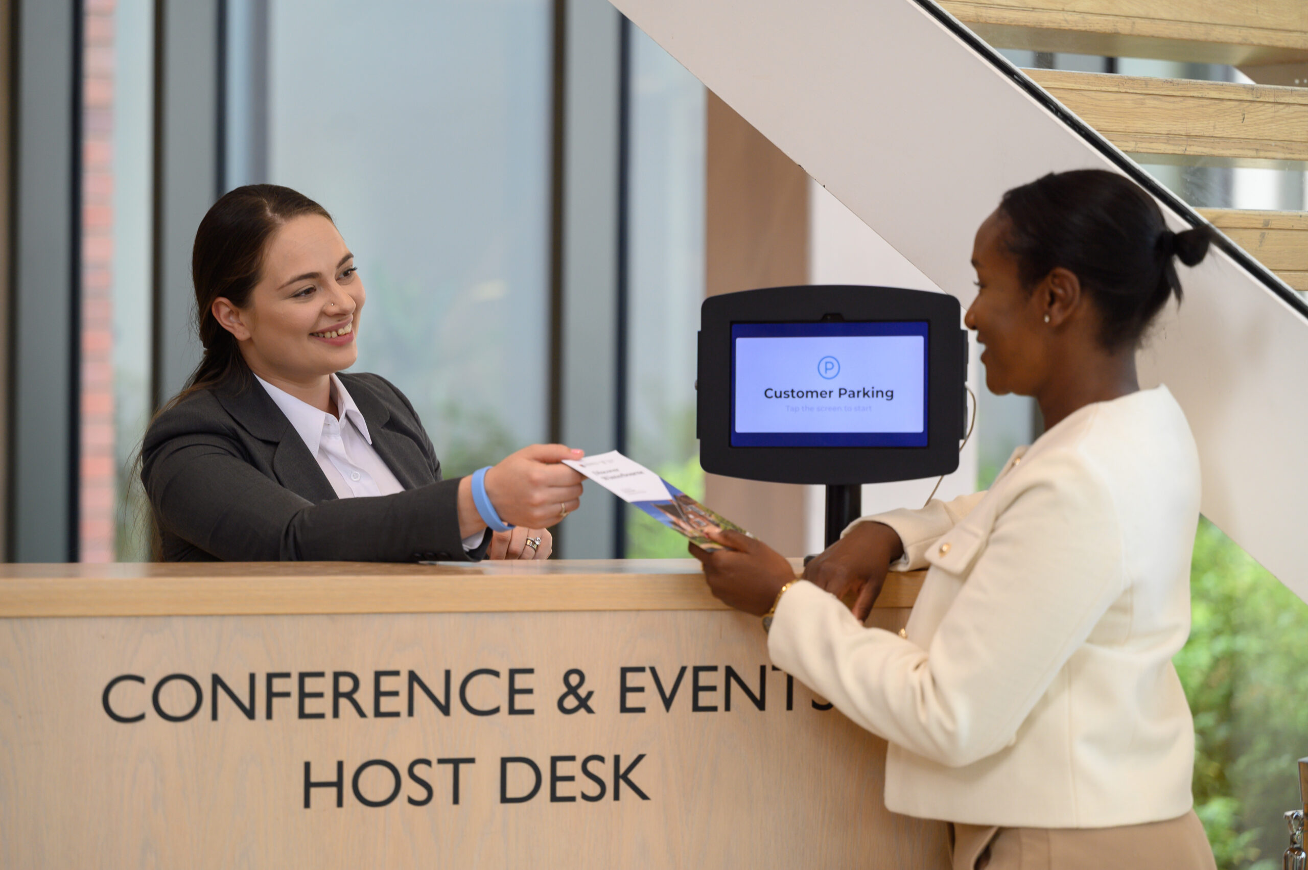 A guest receiving a brochure from the receptionist
