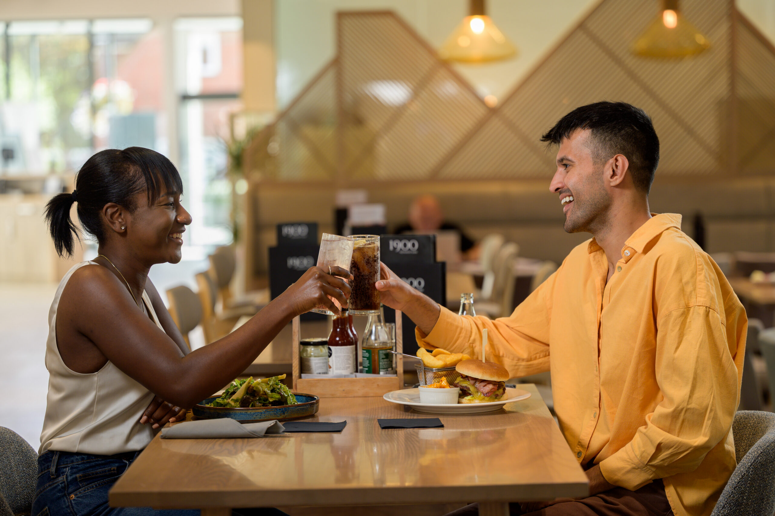A couple clinking glasses at the dining table
