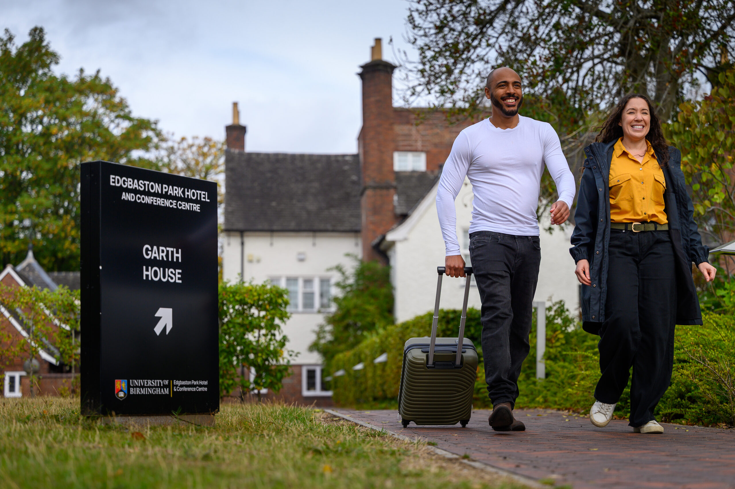 Couple walking with luggage from Garth House